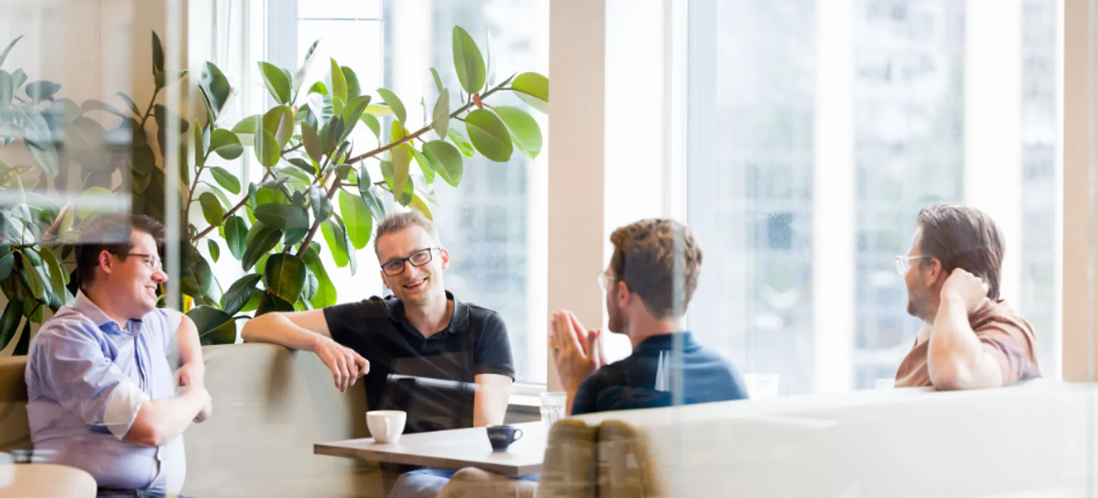 RS-Finance-werken-bij-RS-1 Collega's van RS Finance in gesprek met een kop koffie aan tafel.