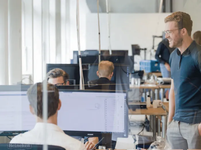 Collega's in gesprek op de werkvloer van RS Finance in Amsterdam