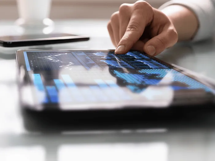 RS-blog-Top-14-KPIs-voor-startups-scale-ups Een persoon gebruikt een tablet met grafieken erop
