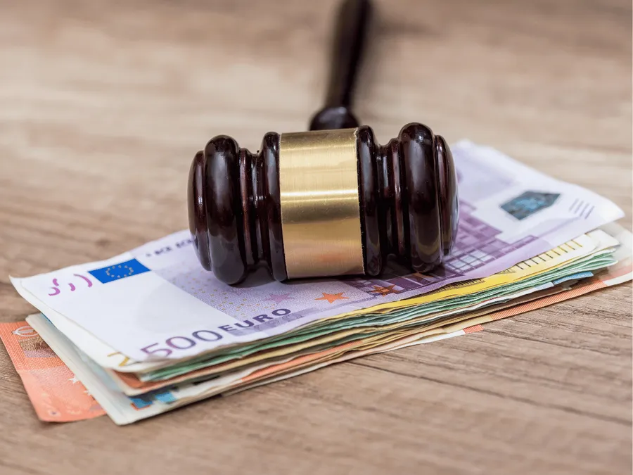 Een rechterhamer ligt op een stapel euro biljetten